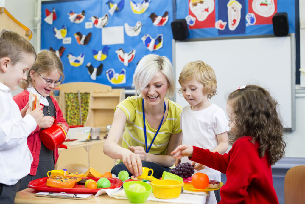 Nursery,Teacher,Playing,Kitchen,Role,Play,With,Her,Students,In